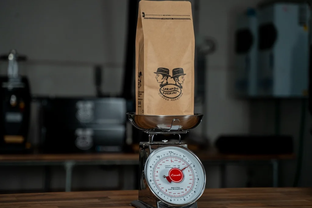 Zak koffiebonen van Lorando & Morini die wordt afgewogen op een weegschaal in de koffiebranderij.